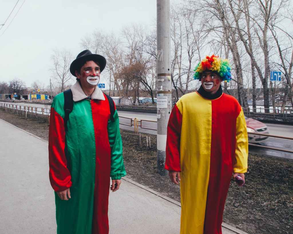 photography of two clowns in the street